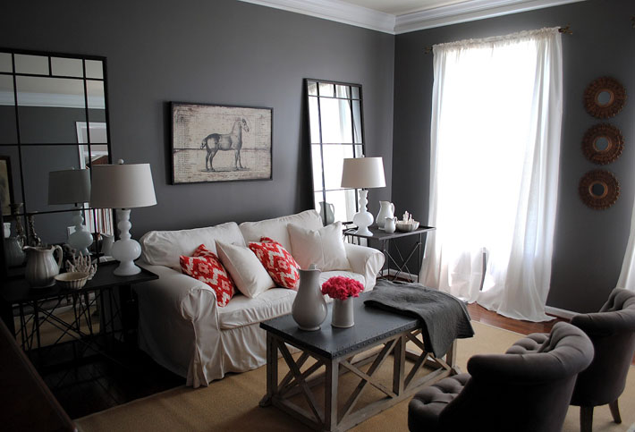 sala com parede cinza e sofá preto