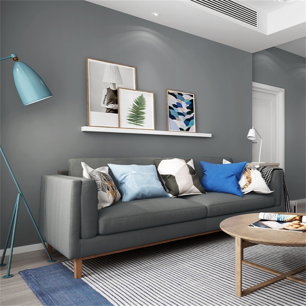 sala com parede cinza e sofá preto